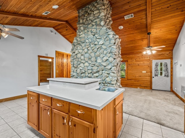 kitchen with wooden ceiling, ceiling fan, high vaulted ceiling, an island with sink, and light colored carpet