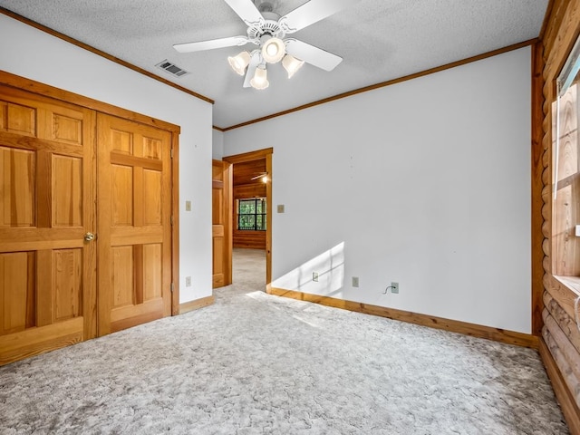 unfurnished bedroom featuring crown molding, a textured ceiling, ceiling fan, and carpet floors