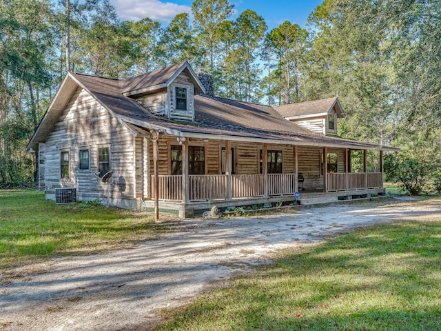 log cabin featuring central AC unit, a front yard, and covered porch