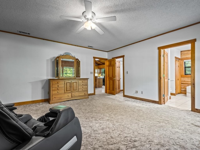 carpeted living room with ceiling fan, a textured ceiling, and ornamental molding