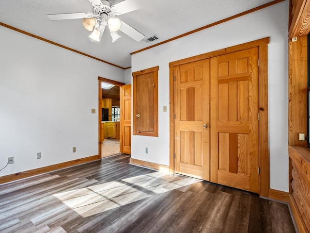 unfurnished bedroom featuring hardwood / wood-style flooring, a textured ceiling, ornamental molding, and ceiling fan