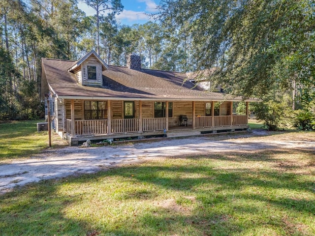 view of front of house with central AC, a front lawn, and covered porch