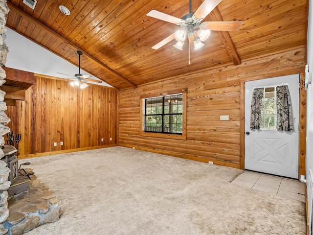 unfurnished living room featuring vaulted ceiling with beams, a wood stove, light carpet, wood ceiling, and ceiling fan