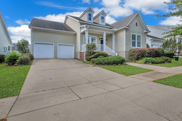 view of front of house with a porch, a garage, and a front lawn