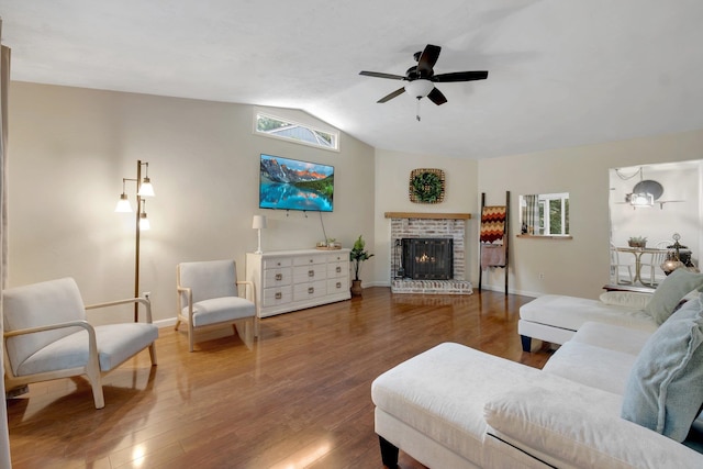 living room with vaulted ceiling, hardwood / wood-style flooring, ceiling fan, and a fireplace