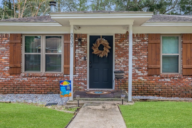 entrance to property featuring a lawn