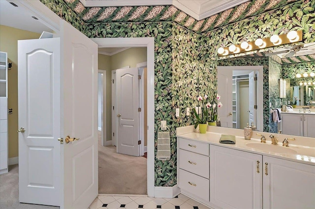 bathroom with baseboards, vanity, and wallpapered walls