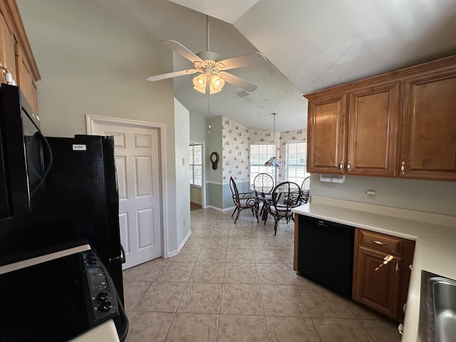 kitchen with ceiling fan, lofted ceiling, light tile patterned floors, brown cabinetry, and black appliances