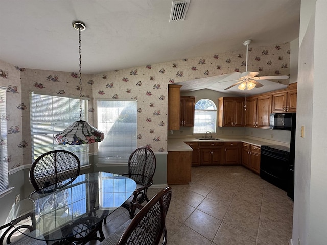 kitchen with visible vents, brown cabinets, black appliances, wallpapered walls, and light countertops