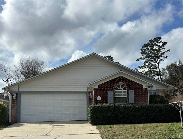 ranch-style home with a garage, brick siding, and concrete driveway