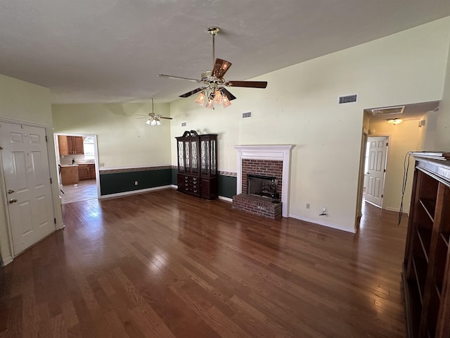 unfurnished living room with visible vents, a fireplace, and dark wood-style flooring