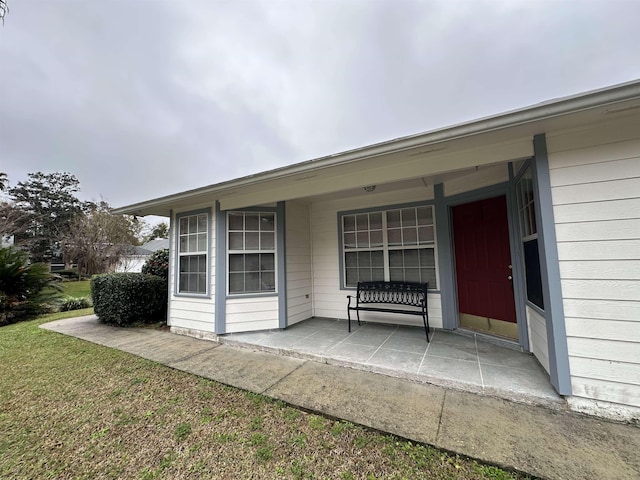 entrance to property with a lawn