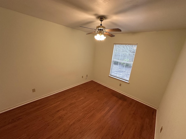 unfurnished room featuring baseboards, ceiling fan, and dark wood-style flooring