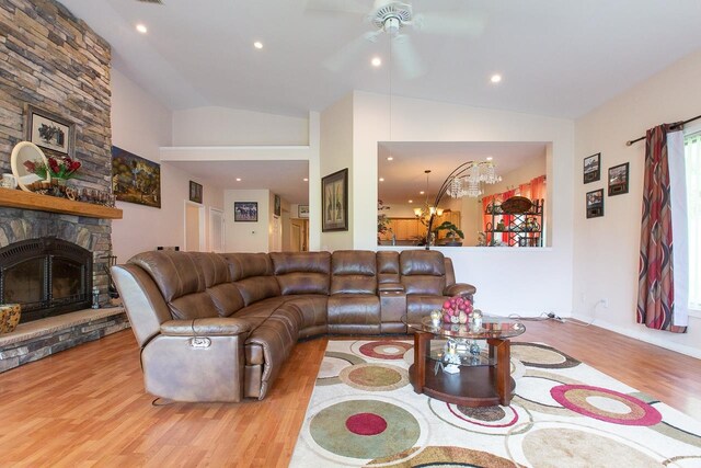 living room featuring light wood-type flooring, ceiling fan with notable chandelier, and lofted ceiling