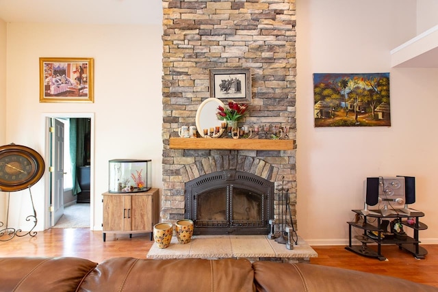 living room featuring a stone fireplace and hardwood / wood-style flooring