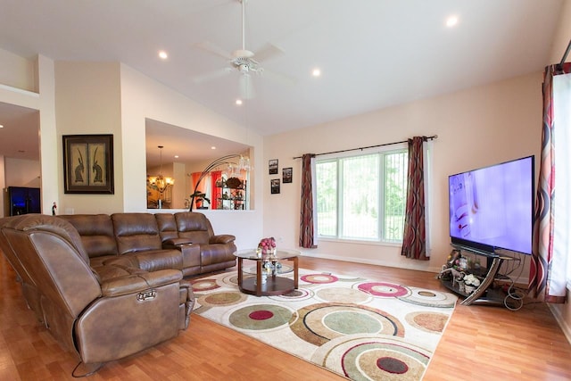 living room with hardwood / wood-style floors, ceiling fan with notable chandelier, and lofted ceiling