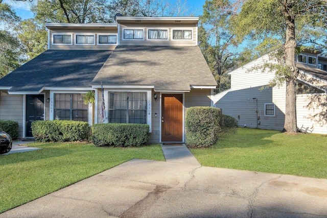 view of front of home featuring a front lawn and a shingled roof