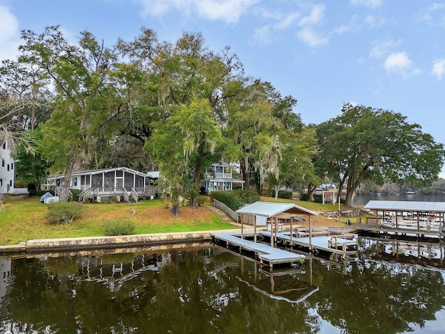 dock area with a water view and a yard