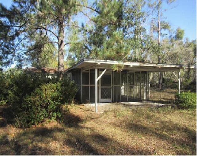 view of outbuilding with a carport and a sunroom