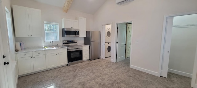 kitchen with stacked washing maching and dryer, appliances with stainless steel finishes, vaulted ceiling with beams, white cabinets, and an AC wall unit