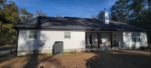 rear view of property with central AC unit and a patio