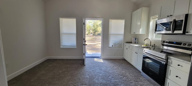 kitchen featuring appliances with stainless steel finishes, sink, white cabinets, and dark carpet