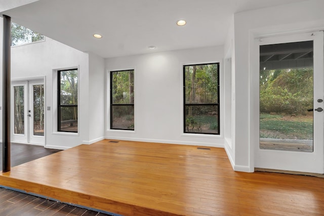 interior space featuring visible vents, baseboards, wood finished floors, and recessed lighting