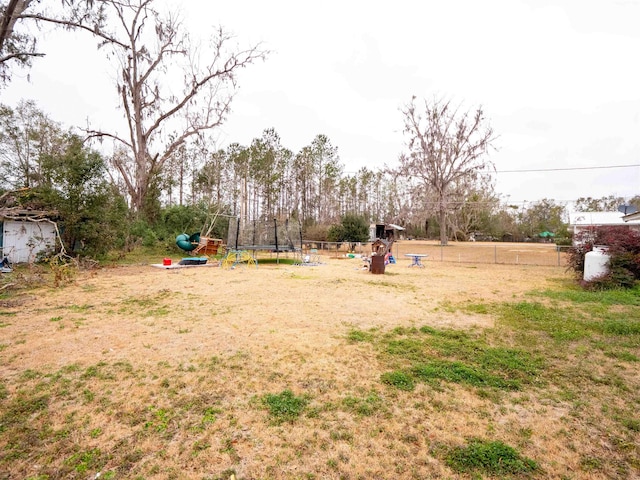 view of yard featuring a trampoline and a playground