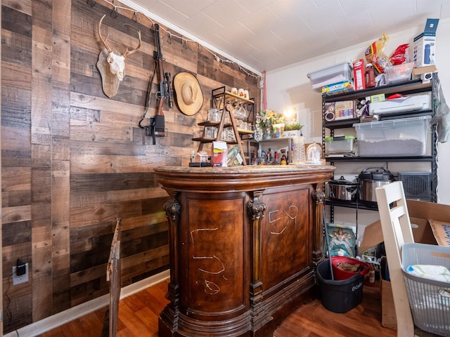 bar with hardwood / wood-style floors and wood walls