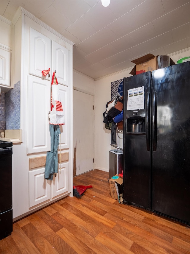 kitchen with white cabinetry, light hardwood / wood-style flooring, and black appliances