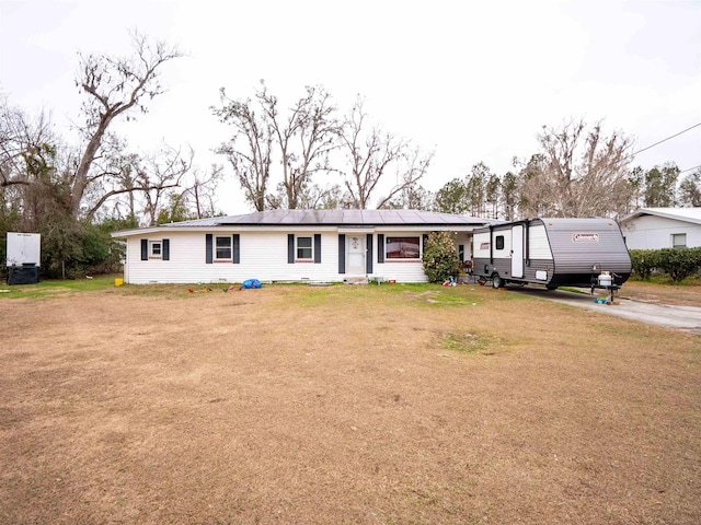 view of front of house featuring solar panels and a front lawn