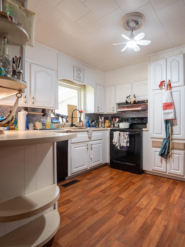 kitchen featuring black range with electric stovetop, light hardwood / wood-style floors, sink, and white cabinets