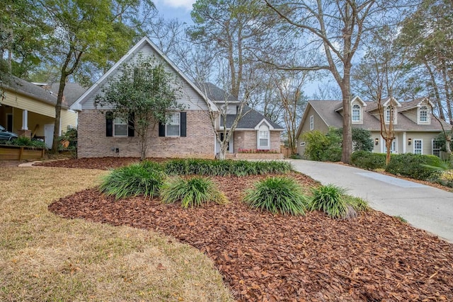 view of front of home with concrete driveway, brick siding, crawl space, and a front yard