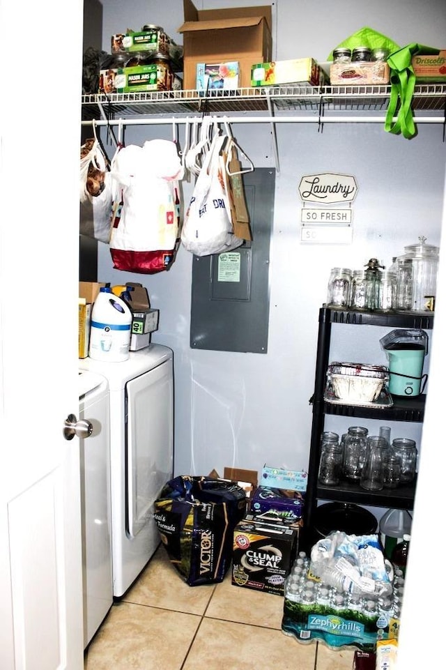 clothes washing area featuring light tile patterned floors and washing machine and clothes dryer