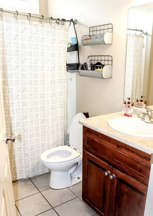 bathroom featuring vanity, tile patterned floors, and toilet