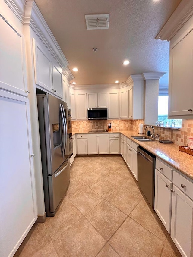 kitchen with stainless steel appliances, white cabinets, and sink