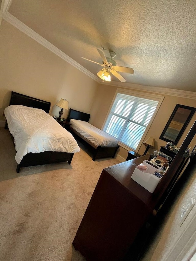 carpeted bedroom featuring a textured ceiling, ornamental molding, and ceiling fan