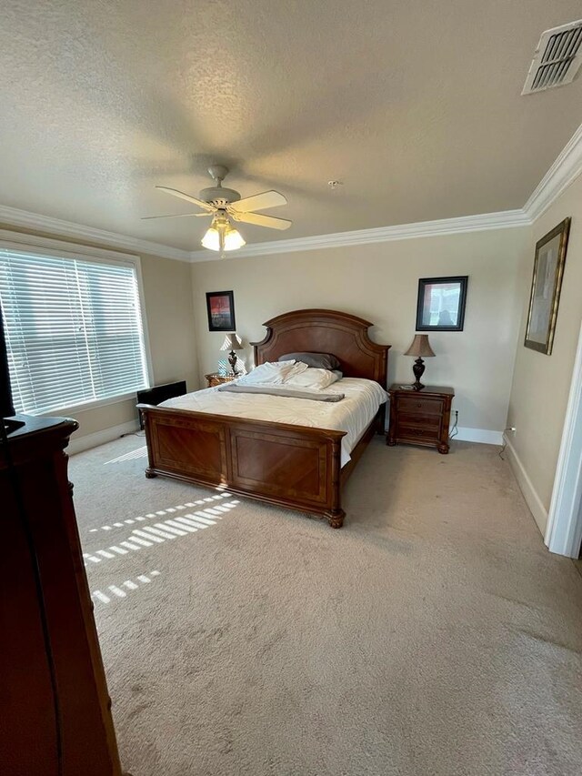 carpeted bedroom with ceiling fan, a textured ceiling, and crown molding