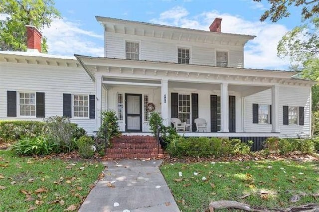 view of front facade with covered porch and a front lawn