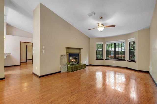 2825 Ohara Dr, Tallahassee, FL 32309 - unfurnished living room with lofted ceiling, a ceiling fan, light wood finished floors, a tiled fireplace, and baseboards