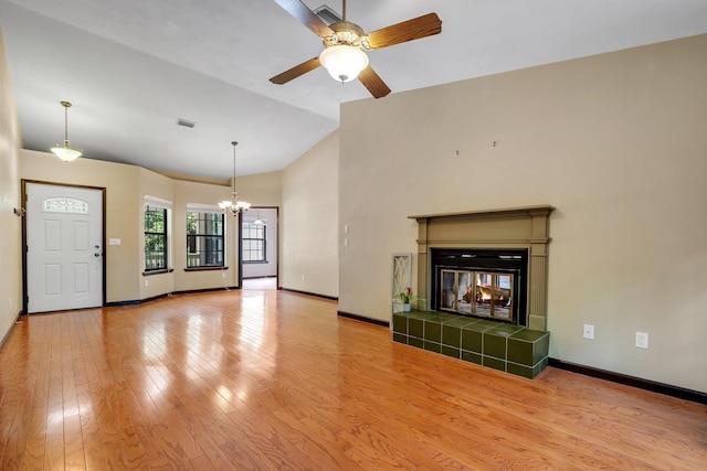 2825 Ohara Dr, Tallahassee, FL 32309 - unfurnished living room featuring a chandelier, a ceiling fan, baseboards, light wood-style floors, and a tile fireplace