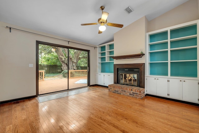 2825 Ohara Dr, Tallahassee, FL 32309 - unfurnished living room with vaulted ceiling, light wood finished floors, ceiling fan, a brick fireplace, and baseboards