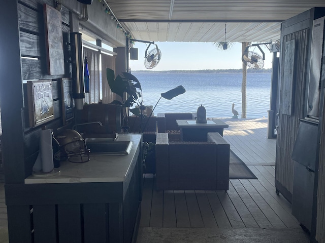 wooden terrace featuring a water view and a sink