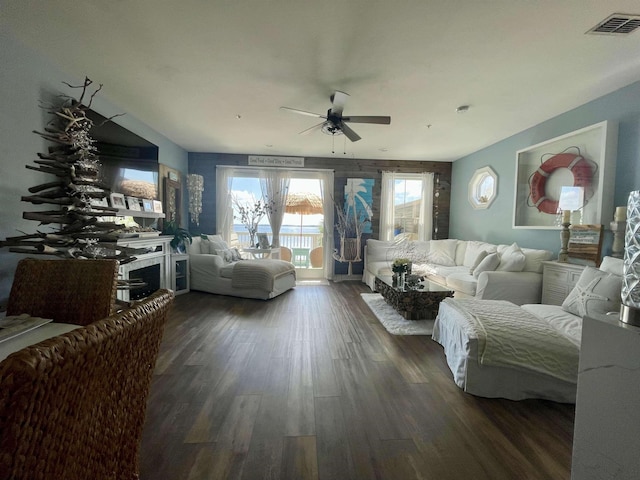 living area with ceiling fan, visible vents, and dark wood-style flooring