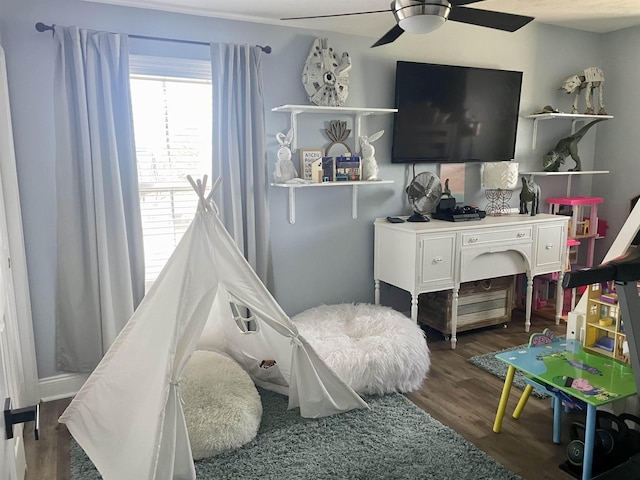 rec room with a ceiling fan and dark wood finished floors