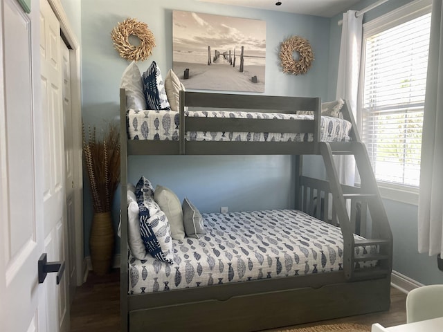 bedroom featuring a closet, baseboards, and wood finished floors