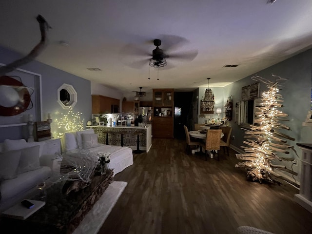 living area with dark wood-style floors, visible vents, and a ceiling fan