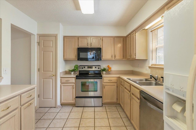 kitchen with light countertops, stainless steel appliances, a sink, and light brown cabinetry