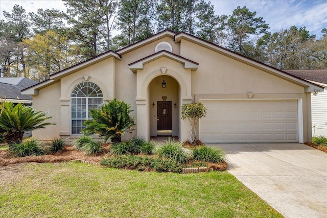 mediterranean / spanish-style home featuring a front yard, driveway, an attached garage, and stucco siding