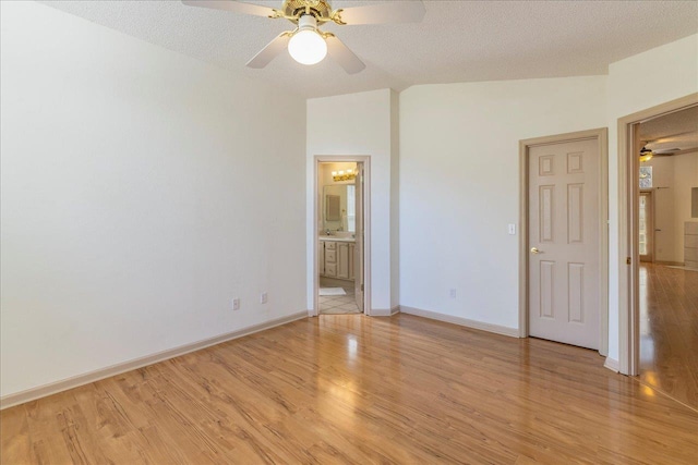 unfurnished bedroom featuring a textured ceiling, connected bathroom, light wood-style flooring, a ceiling fan, and baseboards